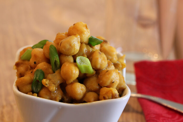 chickpeas in a white bowl with red napkin on table